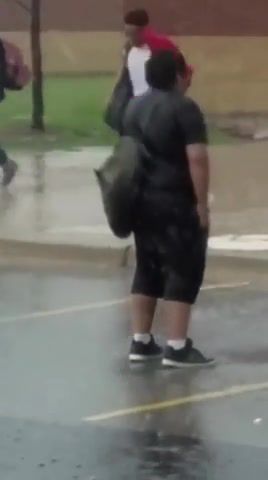 Kid standing in rain while everyone is running, nature travel.