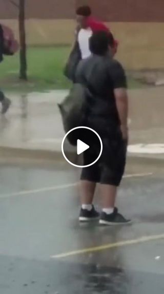 Kid standing in rain while everyone is running