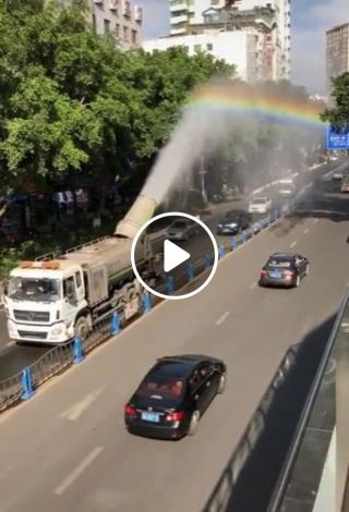 Water spray truck creates rainbow